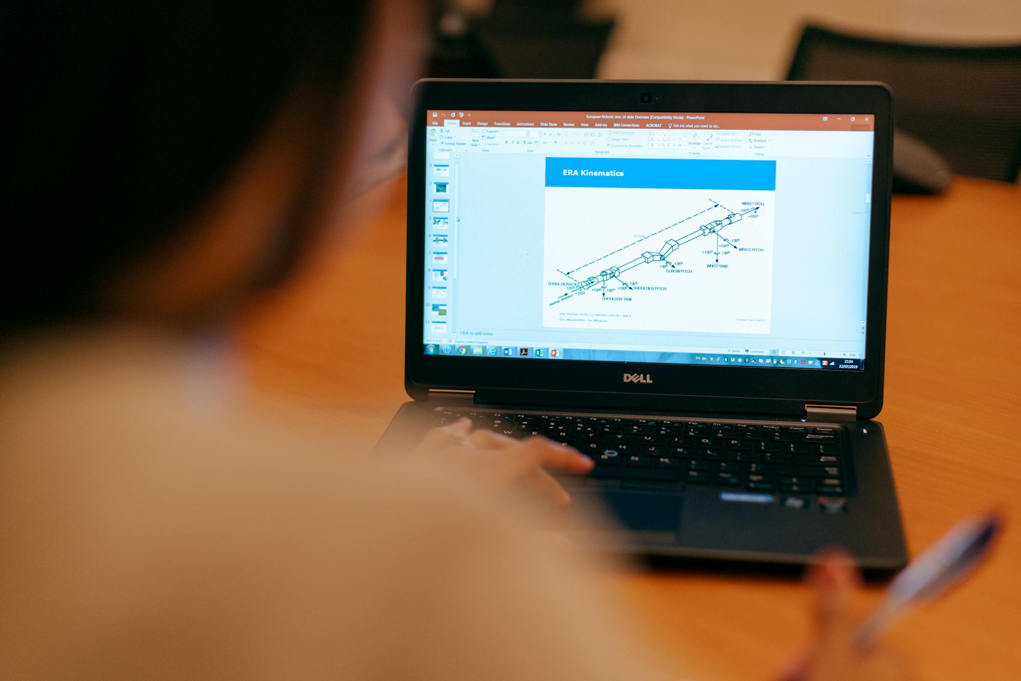 Female engineer working on laptop reviewing technical engineering presentation.